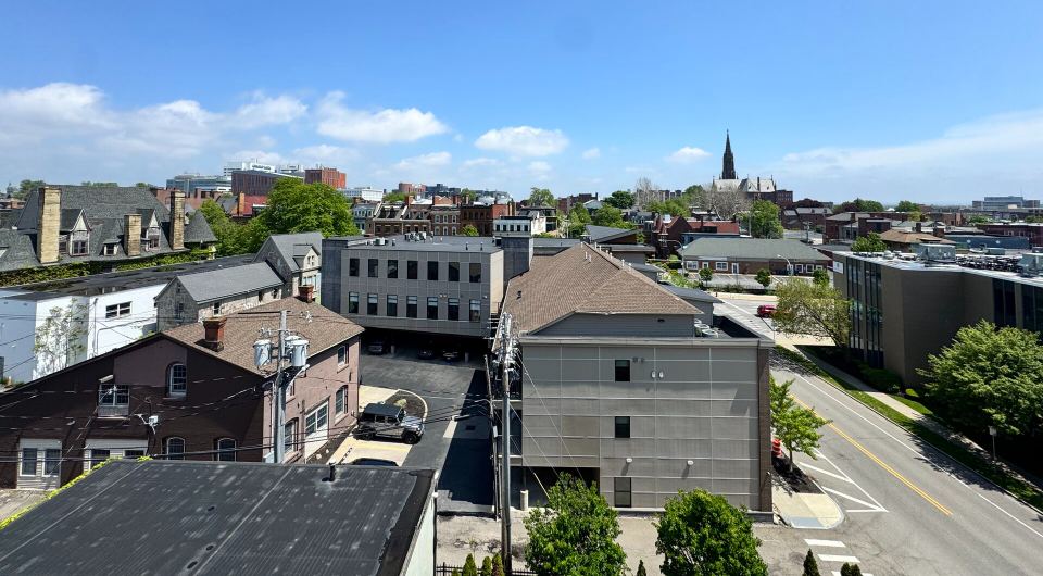 View from the rooftop: Allentown's rooftops and a church spire, with the city beyond
